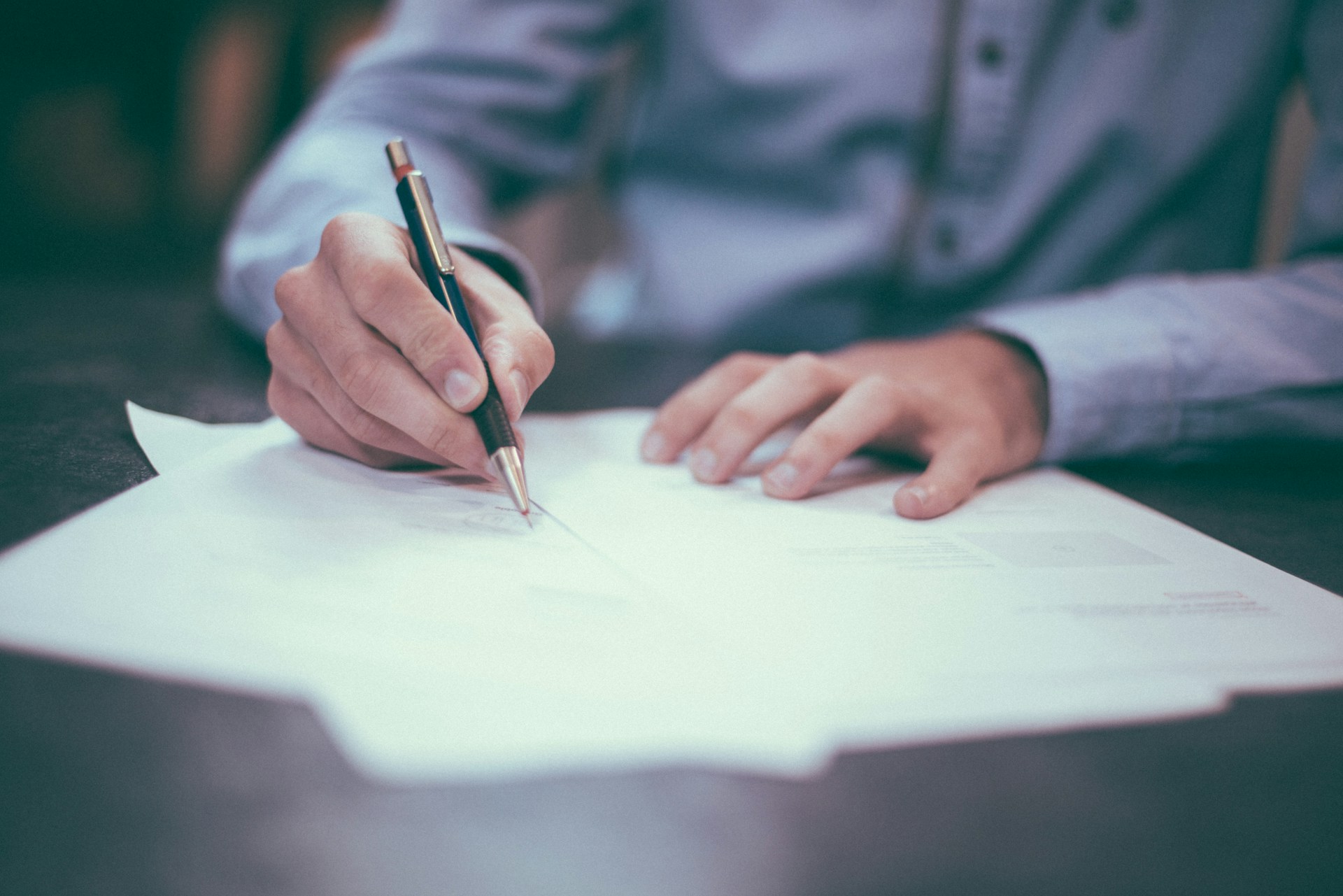 Unidentifiable person signing a contract.